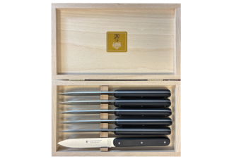 Un coffret de 6 couteaux de table Claude Dozorme Navette 6.16 – Manche noir mat, comprenant six couteaux à steak au manche noir mat, soigneusement rangés dans un coffret en bois dont le couvercle est ouvert pour laisser apparaître une étiquette Claude Dozorme dorée à l'intérieur.
