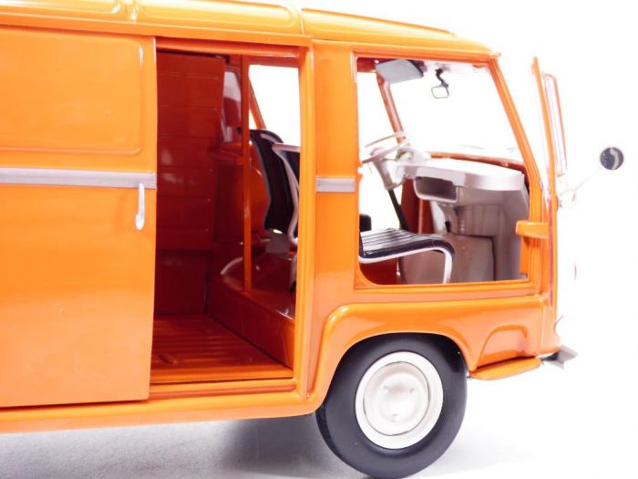 Une voiture miniature Norev Renault Estafette 1959 orange à l’échelle 1/18, dont la porte avant et la porte latérale coulissante sont ouvertes, laissant apparaître le siège conducteur, le volant et une partie de l’habitacle vide.